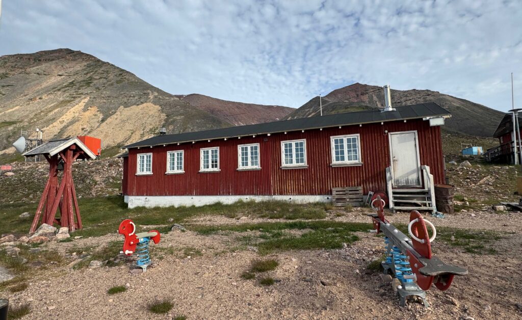 Red building with playground in front of it